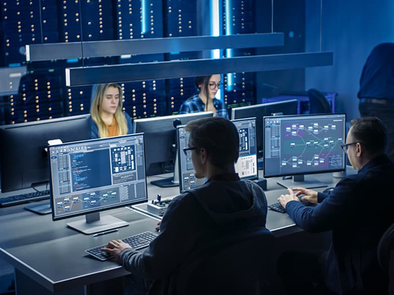 Cybersecurity professionals monitoring network systems in a data center with real-time threat analysis and secure IT infrastructure management.